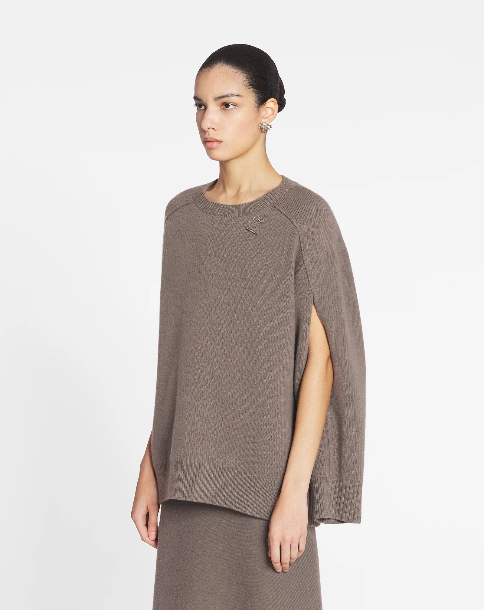 Cape sweater with a cat pin